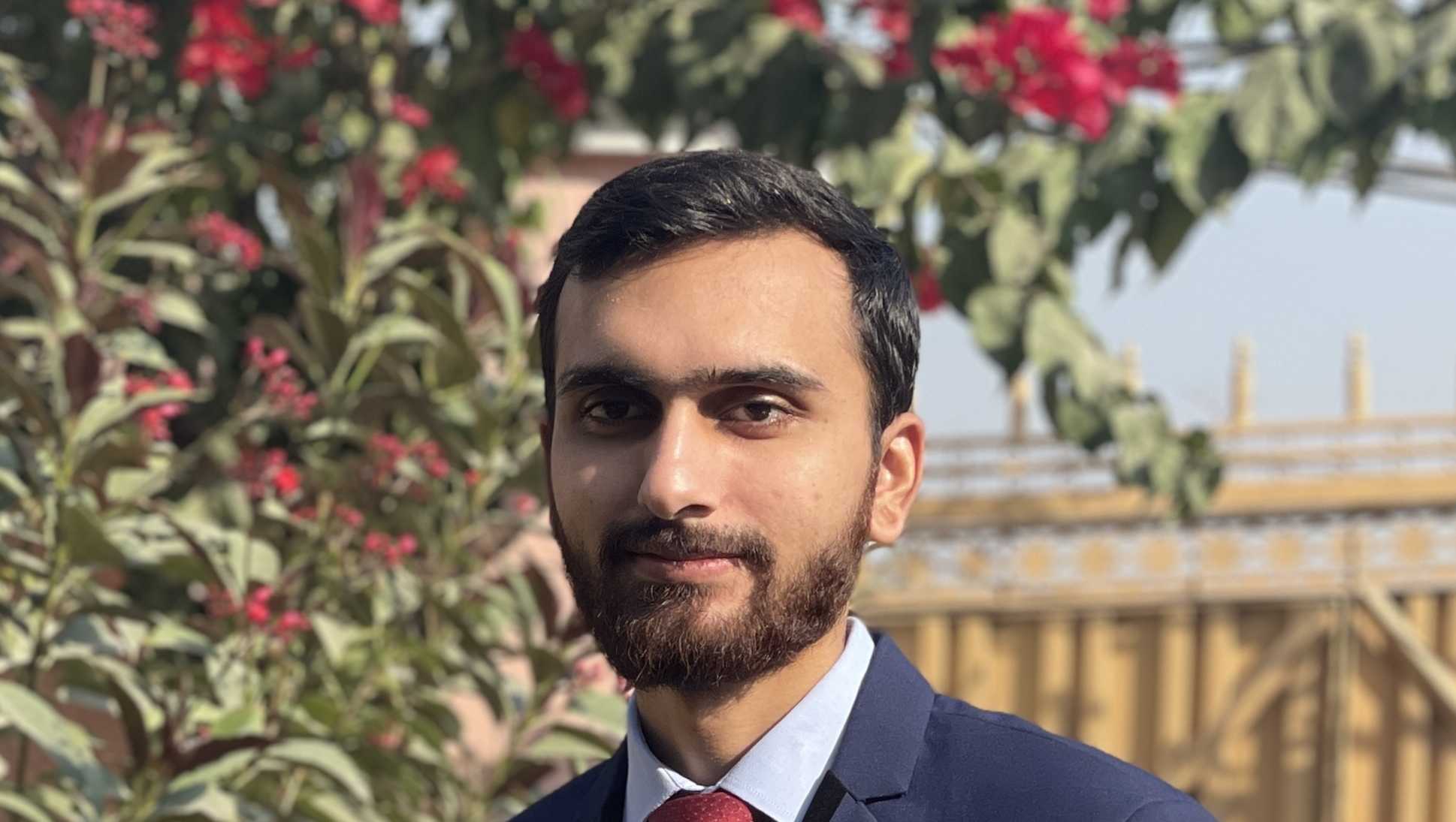 A picture of Saad wearing a navy blue three piece suit